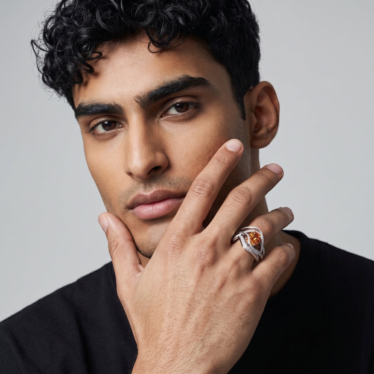 YFS Designs Eternity ring featuring a cushion-cut orange hessonite in 14K yellow and white gold on a man's hand.